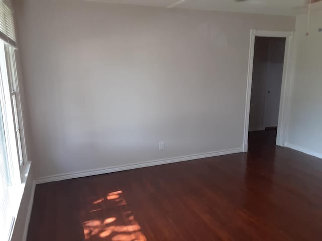 unfurnished room with dark hardwood / wood-style flooring