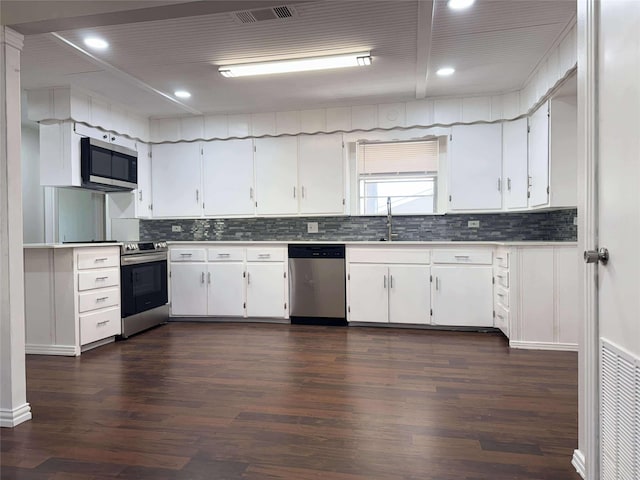 kitchen with visible vents, appliances with stainless steel finishes, dark wood-style floors, white cabinets, and a sink