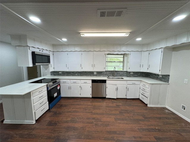 kitchen with sink, appliances with stainless steel finishes, white cabinetry, dark hardwood / wood-style floors, and decorative backsplash