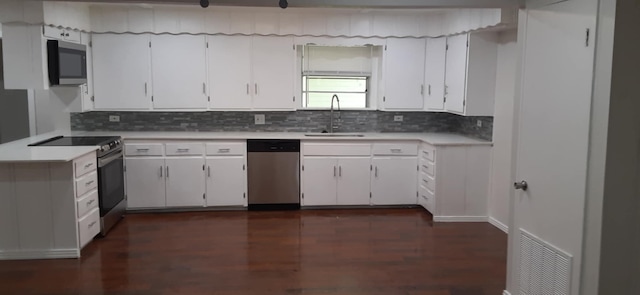 kitchen with white cabinetry, appliances with stainless steel finishes, sink, and backsplash