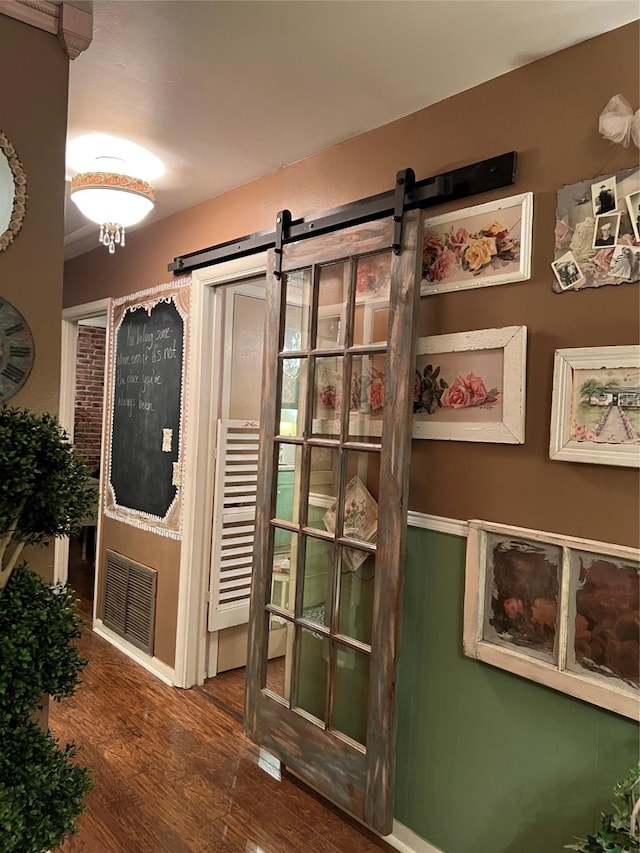 room details with a barn door and hardwood / wood-style floors