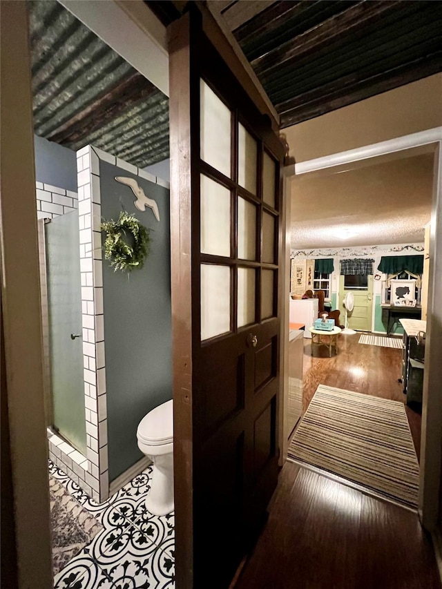 bathroom with hardwood / wood-style floors, toilet, and walk in shower