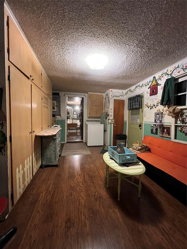 unfurnished dining area with a textured ceiling, washer / dryer, and dark hardwood / wood-style flooring