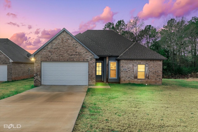 view of front of property with a garage and a yard