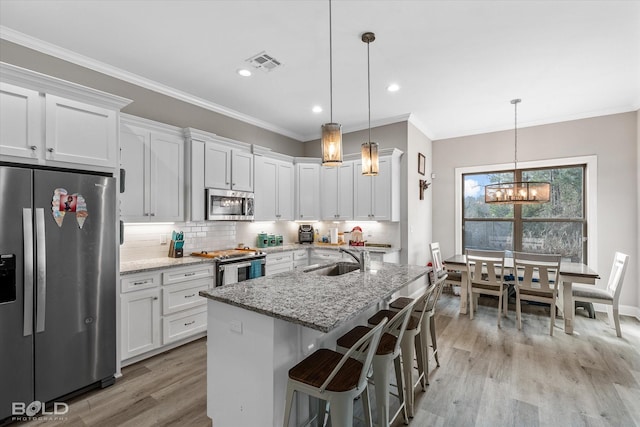 kitchen with light stone countertops, stainless steel appliances, and white cabinetry