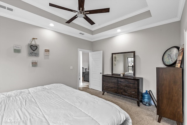 carpeted bedroom with a raised ceiling, ornamental molding, and ceiling fan