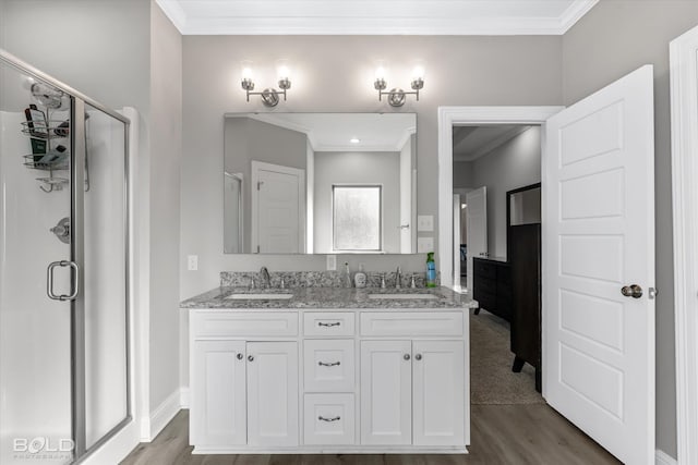 bathroom featuring vanity, hardwood / wood-style flooring, an enclosed shower, and crown molding