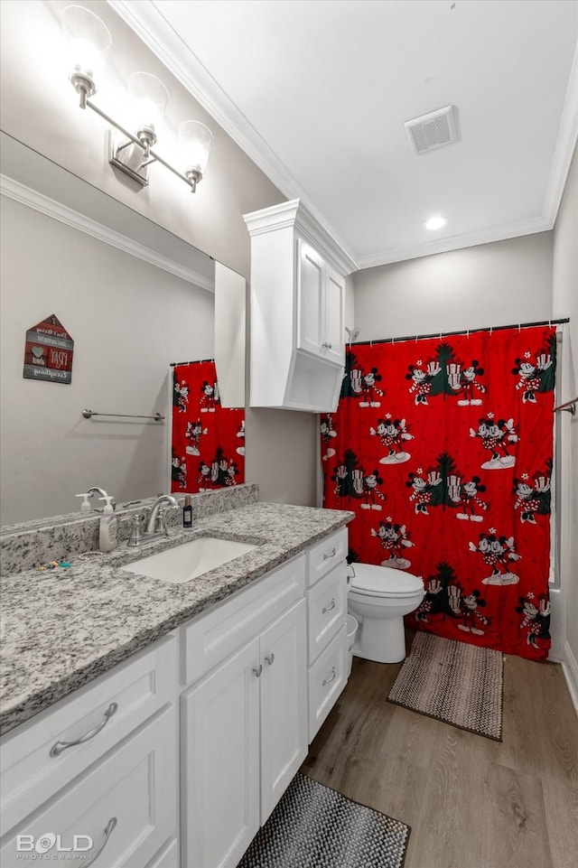 bathroom with toilet, vanity, ornamental molding, and hardwood / wood-style flooring