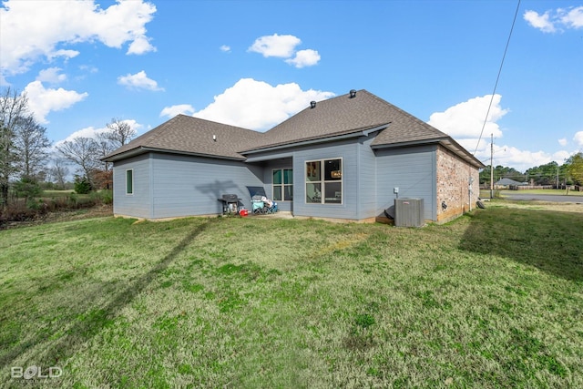 back of house featuring a lawn and central air condition unit