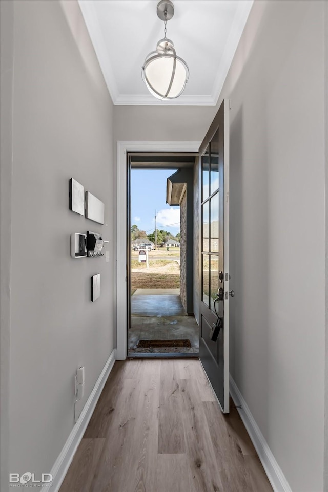 entryway featuring light wood-type flooring and ornamental molding