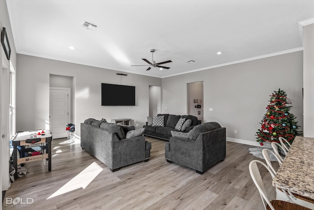 living room featuring light hardwood / wood-style floors, ceiling fan, and ornamental molding