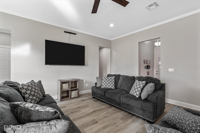 living room featuring ceiling fan, ornamental molding, and light hardwood / wood-style flooring