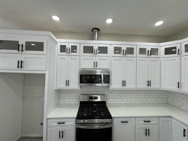 kitchen with white cabinets, appliances with stainless steel finishes, and decorative backsplash