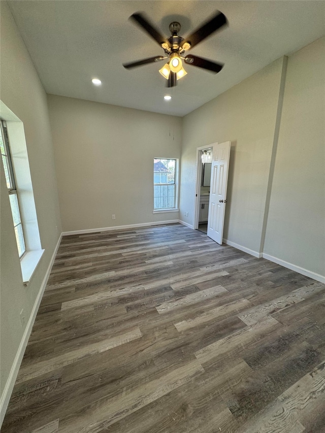 empty room with ceiling fan and dark hardwood / wood-style flooring