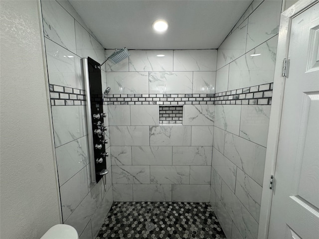 bathroom featuring toilet and tiled shower