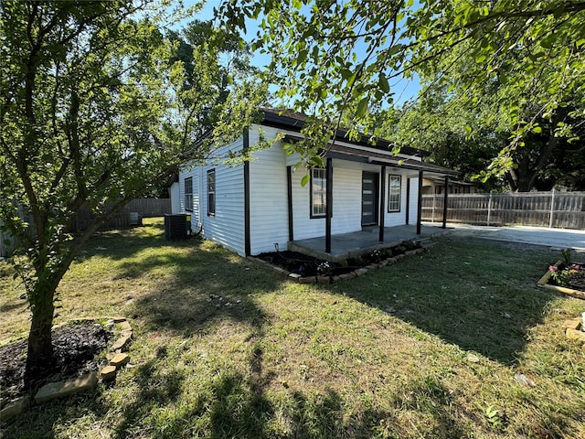 view of front facade featuring central air condition unit, a patio, and a front yard