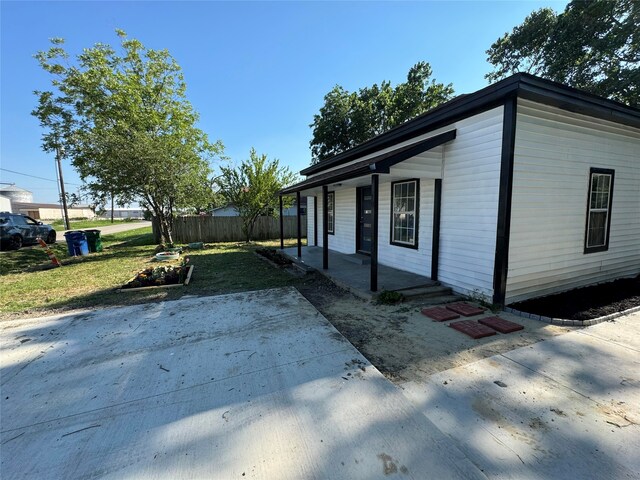 view of home's exterior with covered porch and a yard