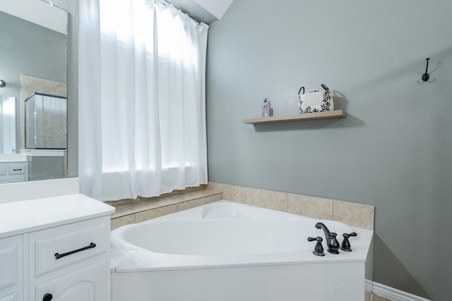 bathroom featuring plus walk in shower and vanity