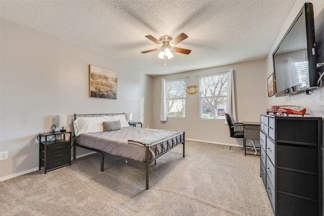 bedroom with ceiling fan, carpet floors, a textured ceiling, and baseboards