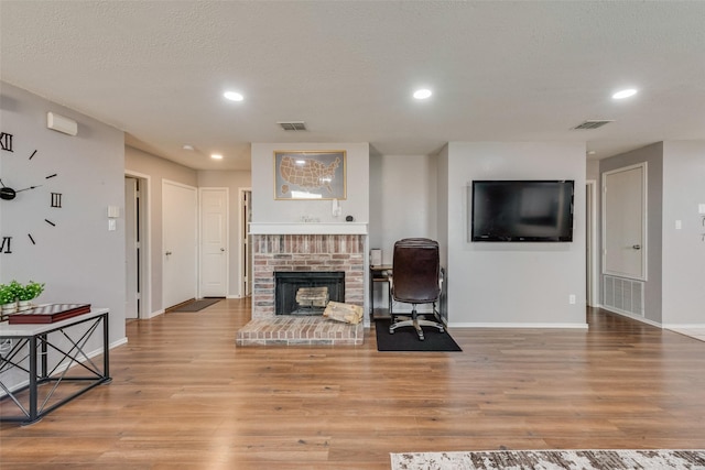 living room with light wood finished floors, visible vents, and recessed lighting