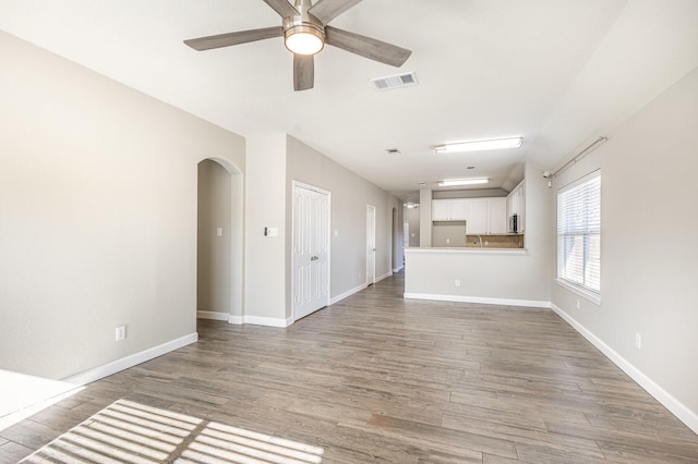 unfurnished living room featuring hardwood / wood-style floors and ceiling fan