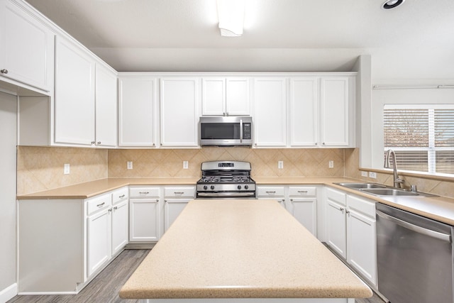 kitchen with sink, white cabinets, wood-type flooring, and appliances with stainless steel finishes