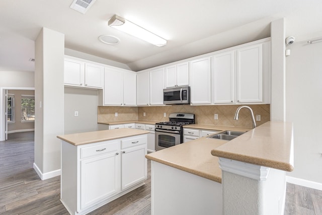 kitchen with appliances with stainless steel finishes, white cabinetry, and sink