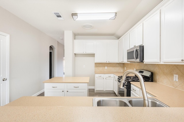 kitchen with tasteful backsplash, white cabinetry, and sink