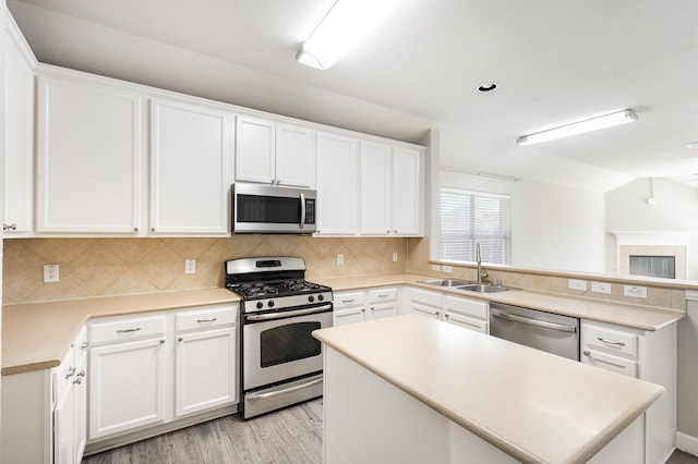 kitchen featuring white cabinets, stainless steel appliances, light hardwood / wood-style floors, and sink