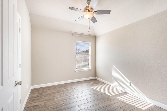 empty room with ceiling fan, wood-type flooring, and lofted ceiling