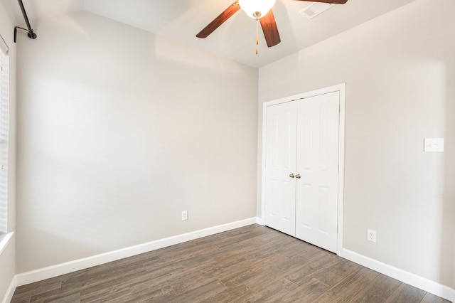 unfurnished bedroom featuring a closet, ceiling fan, and dark wood-type flooring