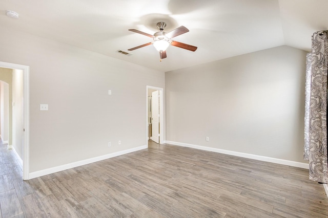 spare room featuring wood-type flooring, ceiling fan, and lofted ceiling