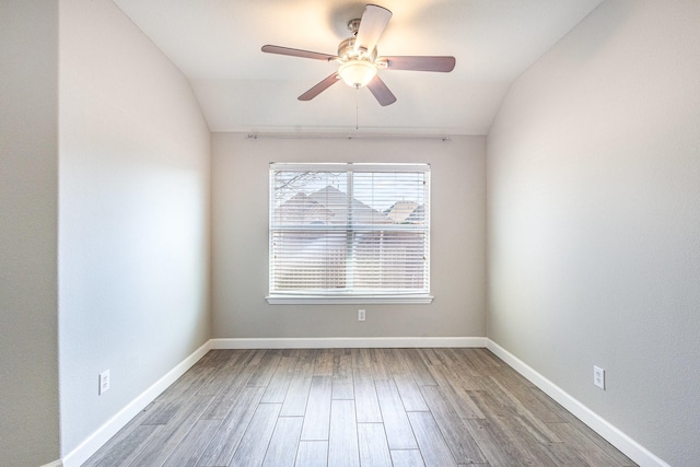 spare room featuring wood-type flooring, ceiling fan, and lofted ceiling