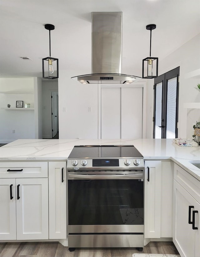 kitchen with white cabinets, decorative light fixtures, island range hood, and stainless steel stove