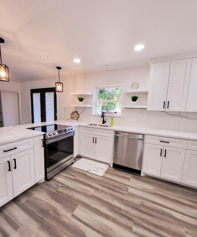 kitchen featuring white cabinets, pendant lighting, stainless steel appliances, and sink