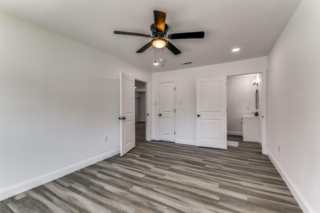 unfurnished bedroom featuring a closet, connected bathroom, ceiling fan, and dark hardwood / wood-style flooring