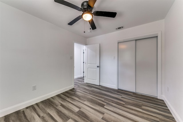 unfurnished bedroom featuring hardwood / wood-style flooring, ceiling fan, and a closet