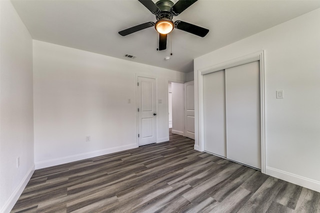 unfurnished bedroom featuring ceiling fan, dark wood-type flooring, and a closet