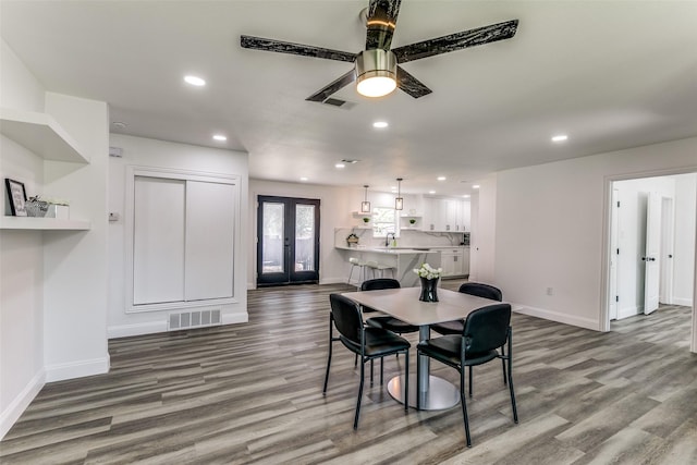 dining room with french doors, light wood-type flooring, ceiling fan, and sink