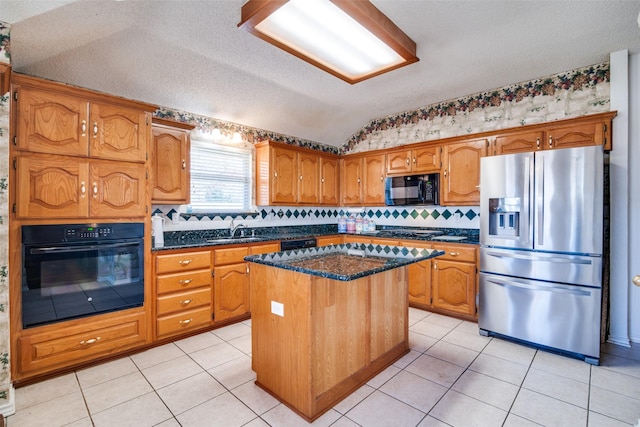 kitchen featuring a center island, lofted ceiling, black appliances, dark stone countertops, and a textured ceiling