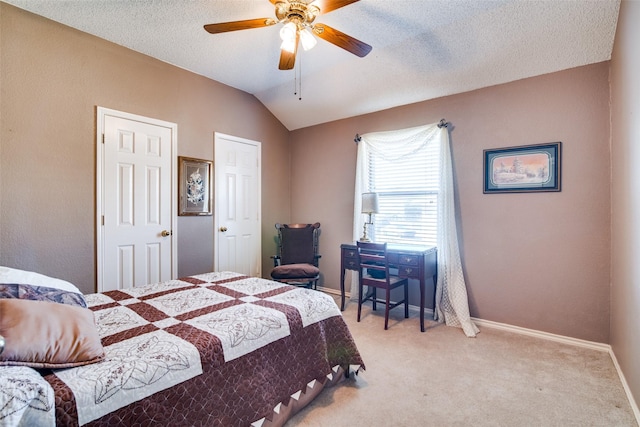 carpeted bedroom with vaulted ceiling, ceiling fan, and a textured ceiling