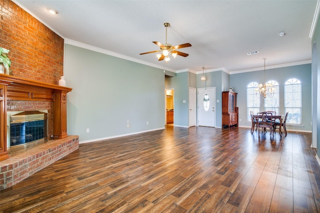 unfurnished living room featuring ceiling fan with notable chandelier, dark hardwood / wood-style floors, a brick fireplace, and ornamental molding