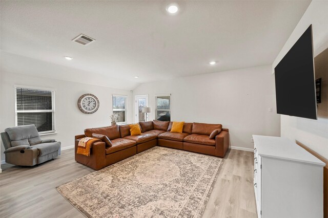 living room featuring light wood-type flooring and vaulted ceiling