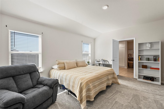 bedroom with light colored carpet and vaulted ceiling