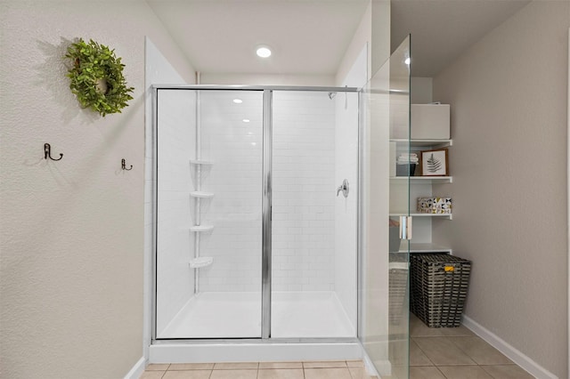 bathroom featuring tile patterned floors and a shower with door