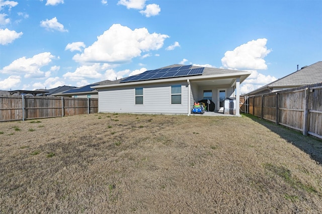 back of property featuring solar panels, a yard, and a patio area