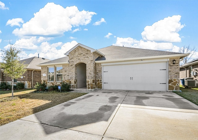 single story home with central air condition unit and a garage