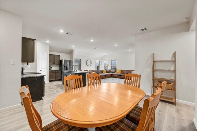 dining room with light hardwood / wood-style floors and sink