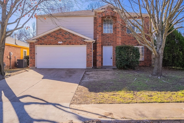 traditional home with central air condition unit, driveway, an attached garage, and brick siding