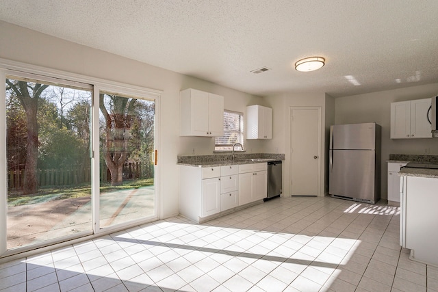 kitchen featuring light tile patterned flooring, sink, white cabinetry, a textured ceiling, and appliances with stainless steel finishes